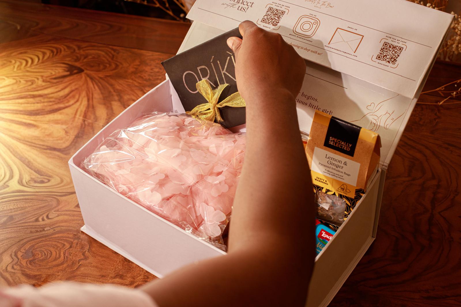 A hand placing a personalised card into a WITB gift box